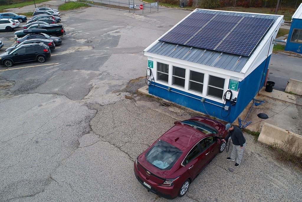 A man charges his electric car at a Portland Campus charging station